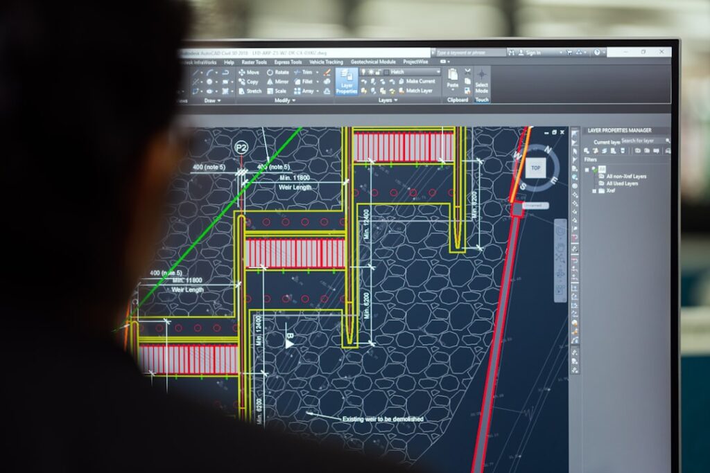 Construction professionals reviewing a BIM model on a large screen in a site office